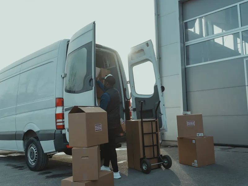 Courier loading parcels into a delivery van